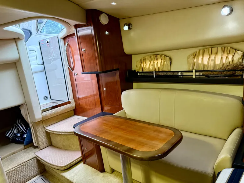 Slide: The Image of Interior of 2006 Sea Ray 290 Sundancer with cozy seating and wooden table. - 21