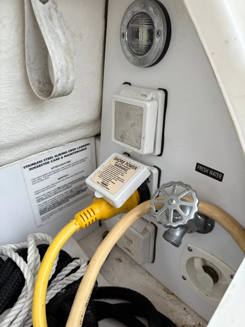 Slide: The Image of 2006 Sea Ray 290 Sundancer boat panel with shore power and fresh water connections. - 28