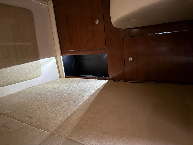 Slide: The Image of Interior cabin of 2006 Sea Ray 290 Sundancer with wood paneling and storage compartments. - 29
