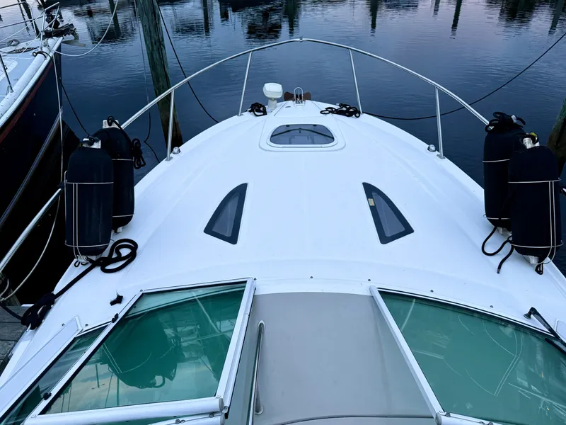 Slide: The Image of 2006 Sea Ray 290 Sundancer boat docked, showing deck and water reflection. - 33
