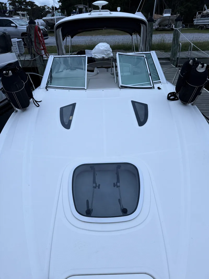 Slide: The Image of 2006 Sea Ray 290 Sundancer boat docked, featuring open deck hatches and sleek design. - 38