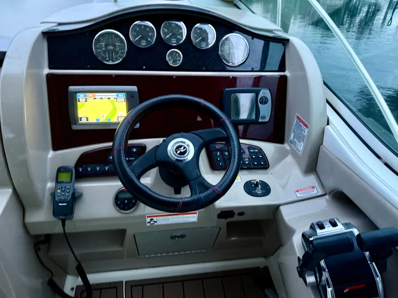 Slide: The Image of 2006 Sea Ray 290 Sundancer helm with steering wheel, gauges, and navigation system. - 5
