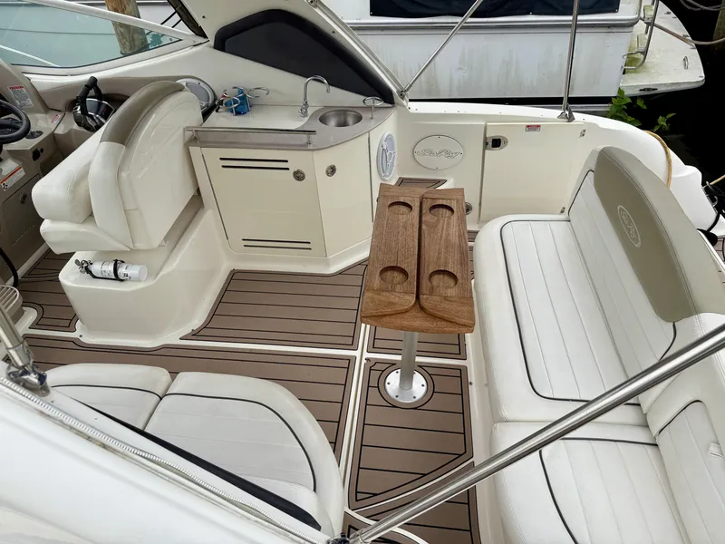 Slide: The Image of 2006 Sea Ray 290 Sundancer interior with seating, table, and kitchenette. - 9
