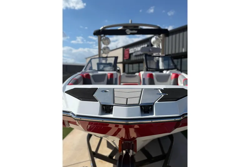 Slide: The Image of 2021 Malibu M240 boat with sleek design, red and white interior, and modern features. - 2