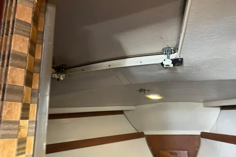 Slide: The Image of Interior view of a 1985 Catalina 30 sailboat cabin with wood accents and ceiling light. - 26