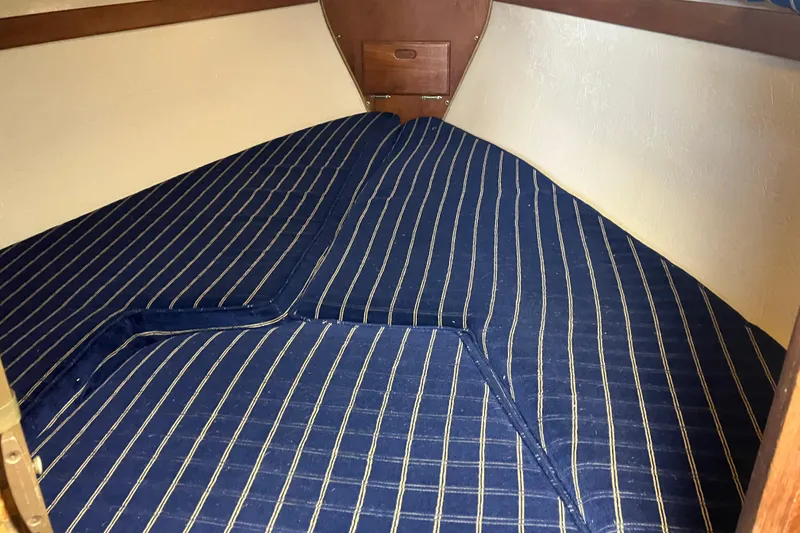 Slide: The Image of V-berth cabin with striped bedding in a 1985 Catalina 30 sailboat. - 25