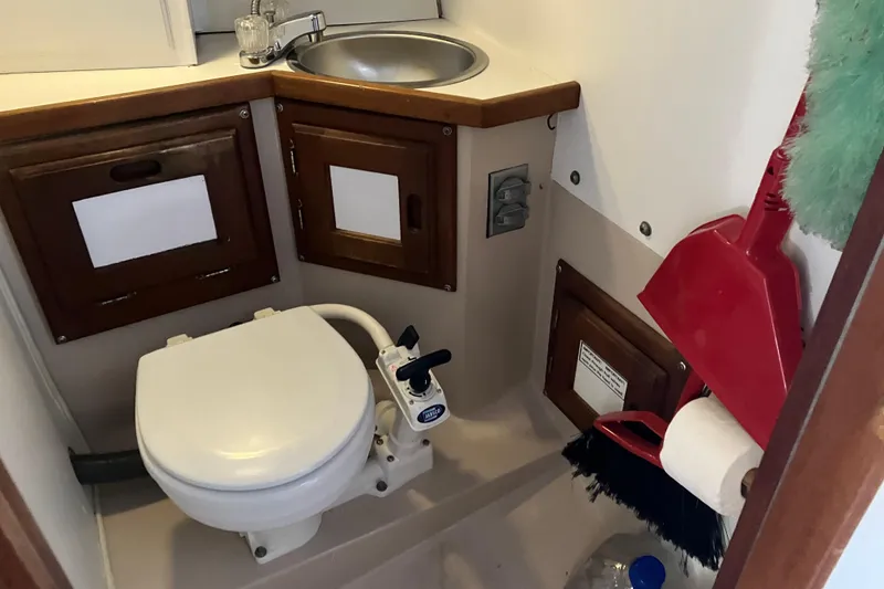 Slide: The Image of Compact bathroom in a 1985 Catalina 30 sailboat with toilet, sink, and storage cabinets. - 40