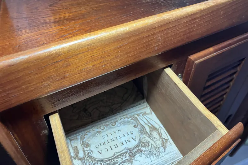 Slide: The Image of Open wooden drawer on 1985 Catalina 30, revealing vintage map design inside. - 32