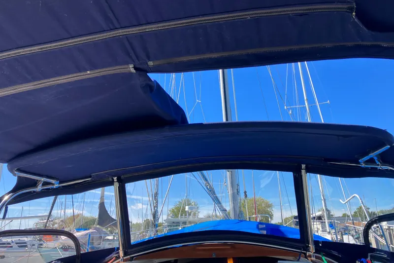 Slide: The Image of Cockpit view of a 1985 Catalina 30 sailboat with blue canopy and clear sky. - 7