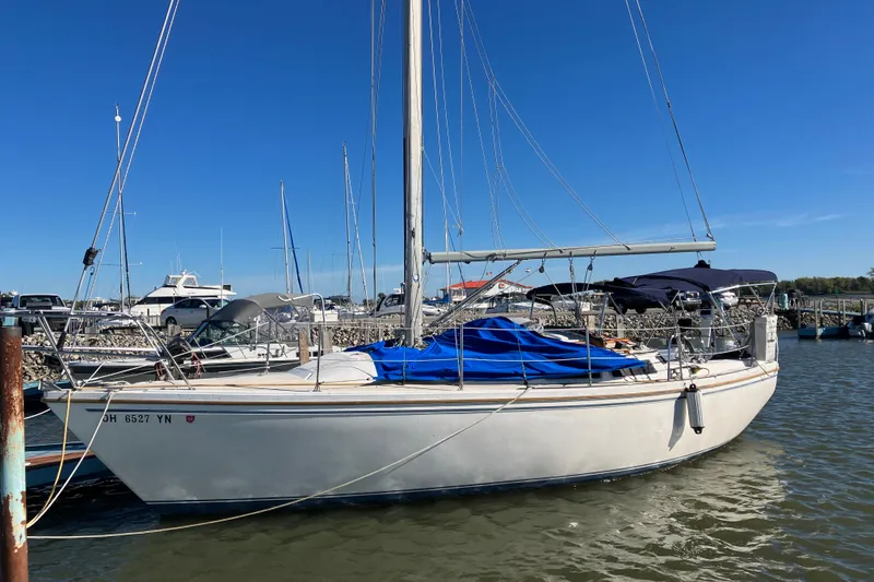 The Image of 1985 Catalina 30 sailboat docked in a marina under clear blue skies. - 0