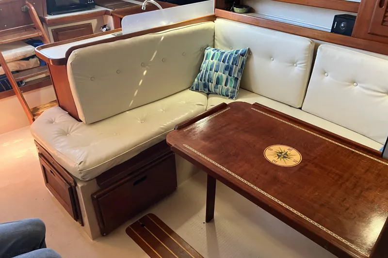 Slide: The Image of Interior of 1985 Catalina 30 sailboat with cushioned seating and wooden table. - 22