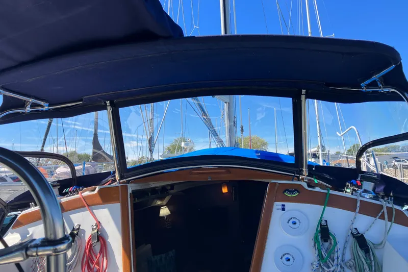 Slide: The Image of 1985 Catalina 30 sailboat cockpit with blue canopy and visible rigging. - 8