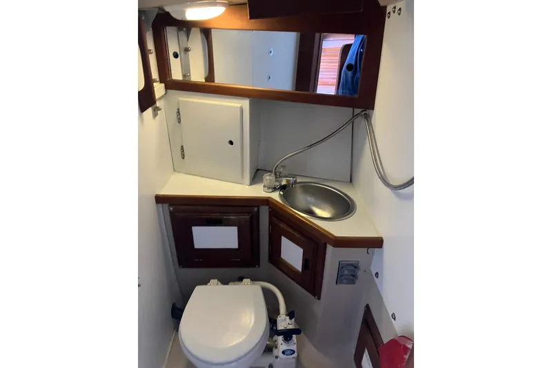 Slide: The Image of Compact bathroom in a 1985 Catalina 30 sailboat with sink, toilet, and mirror. - 33