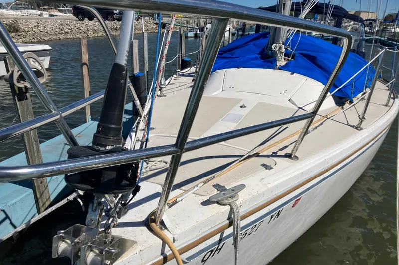 Slide: The Image of 1985 Catalina 30 sailboat docked, featuring a blue cover and stainless steel railings. - 3