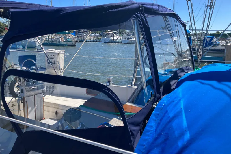 Slide: The Image of 1985 Catalina 30 sailboat cockpit with blue canopy, docked at marina. - 37