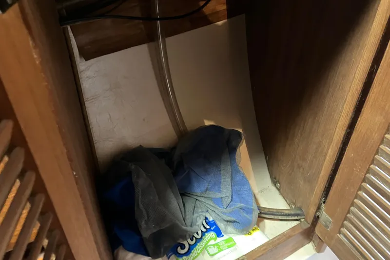 Slide: The Image of Storage compartment in 1985 Catalina 30 sailboat with cleaning supplies and cloth. - 23