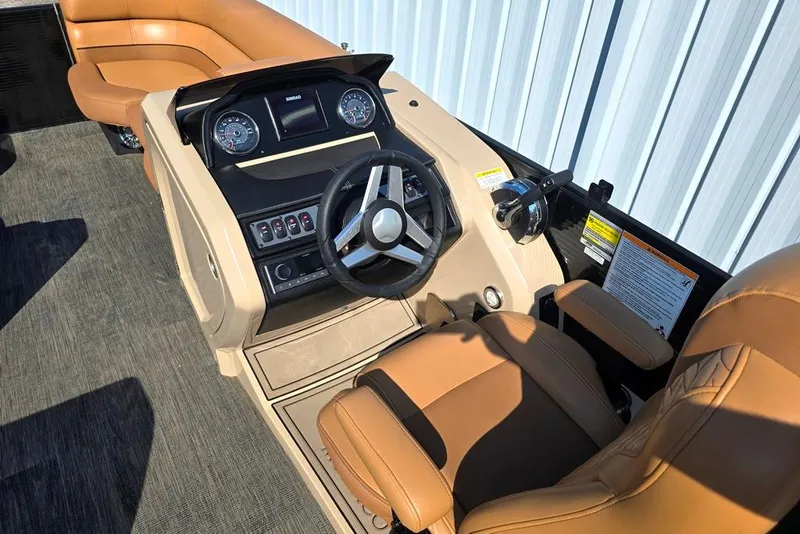 Slide: The Image of 2021 Godfrey Monaco 235 SFL boat interior with steering wheel and tan seating. - 3