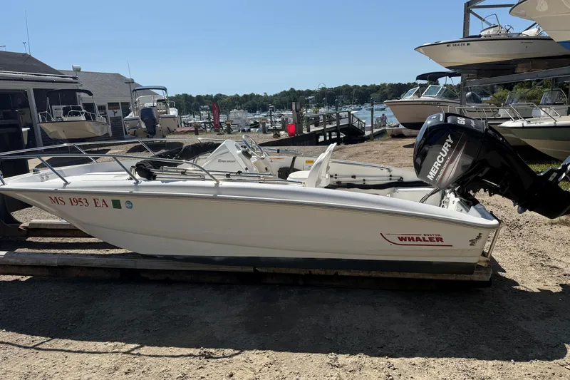 The Image of 2013 Boston Whaler 150 Super Sport boat with Mercury engine, docked outdoors. - 0