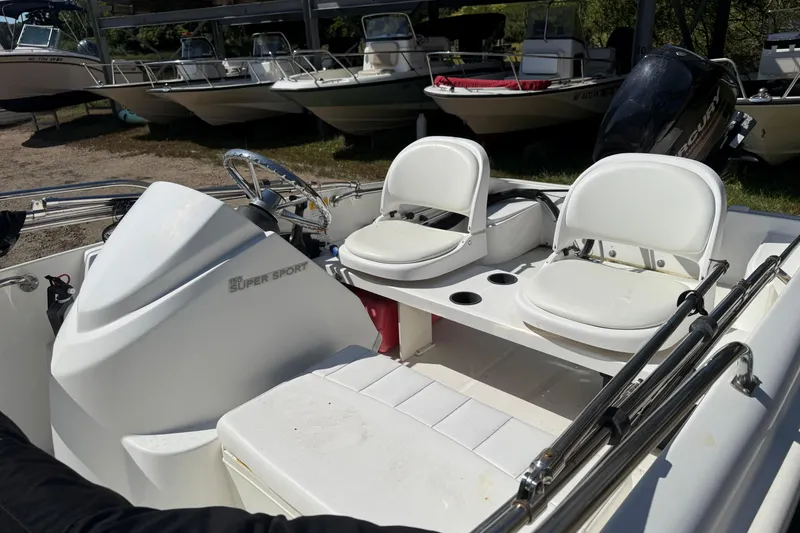 Slide: The Image of 2013 Boston Whaler 150 Super Sport boat interior with steering wheel and seating. - 10