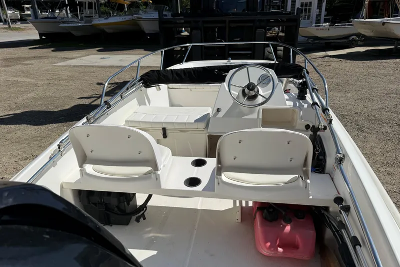 Slide: The Image of 2013 Boston Whaler 150 Super Sport boat interior with steering wheel and seating. - 8