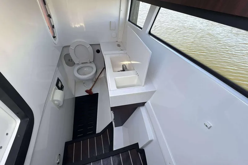 Slide: The Image of 2020 Monterey 378SS Super Sport boat bathroom with toilet, sink, and window view. - 22