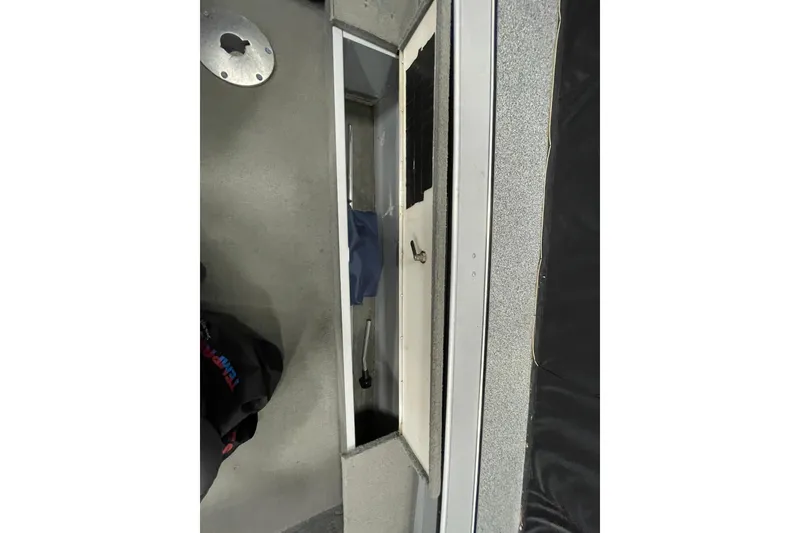 Slide: The Image of Battery compartment of a 1993 Lund 1600 Angler boat, showing wiring and storage. - 11