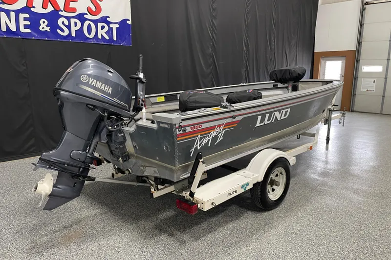 Slide: The Image of 1993 Lund 1600 Angler boat with Yamaha motor on trailer in showroom. - 3