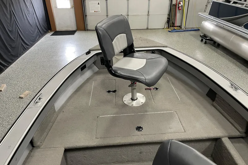 Slide: The Image of 1993 Lund 1600 Angler boat interior with two gray seats and carpeted floor. - 6