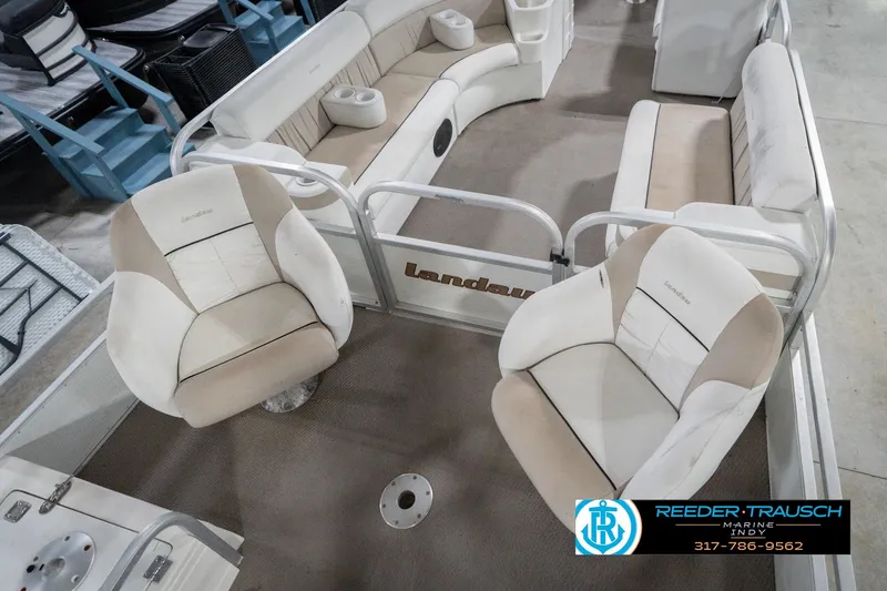 Slide: The Image of 1999 Landau DX24 pontoon boat interior with beige and white seating. - 12