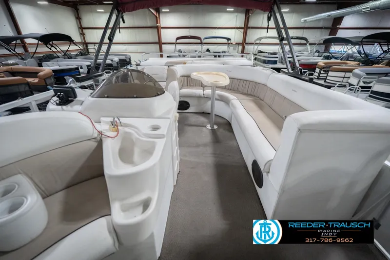 Slide: The Image of 1999 Landau DX24 pontoon boat interior with seating and helm in showroom. - 17