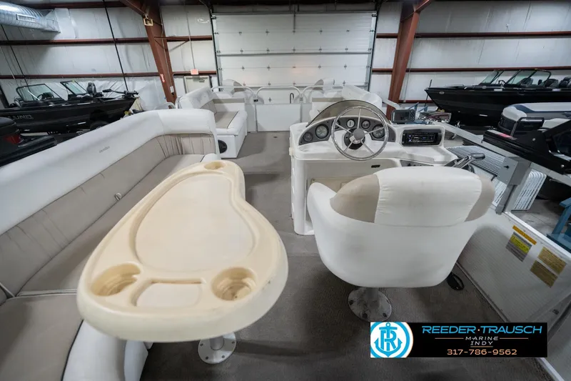 Slide: The Image of Interior of a 1999 Landau DX24 boat with white seating and steering console. - 19