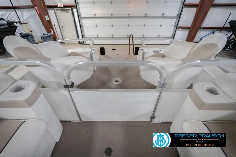 Slide: The Image of Interior of a 1999 Landau DX24 boat with beige seating and cup holders. - 21
