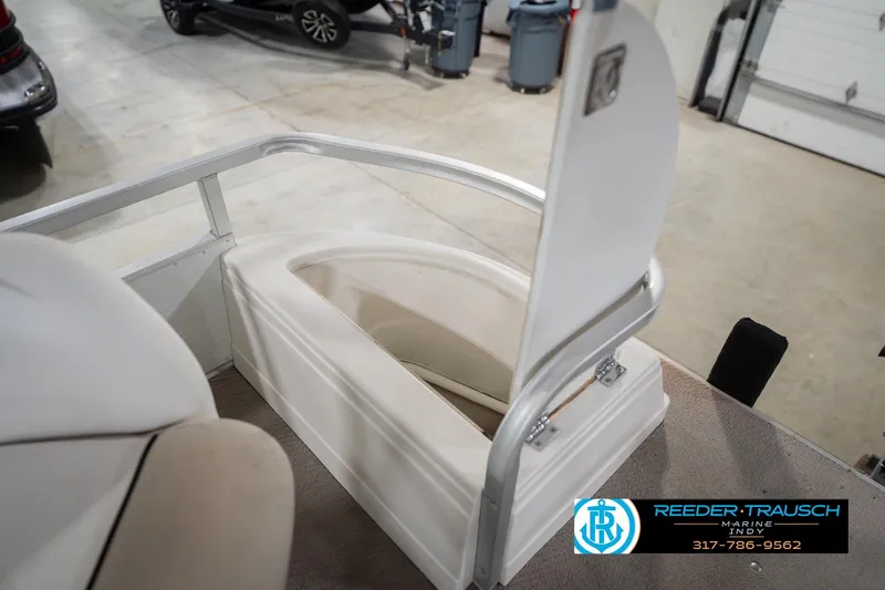 Slide: The Image of 1999 Landau DX24 boat interior with open storage compartment in a garage setting. - 23