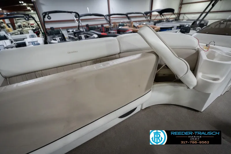 Slide: The Image of Interior of a 1999 Landau DX24 boat with beige seating in a showroom. - 26