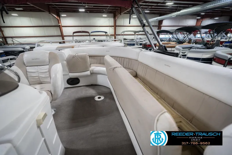 Slide: The Image of Interior of a 1999 Landau DX24 pontoon boat with beige seating in a showroom. - 29
