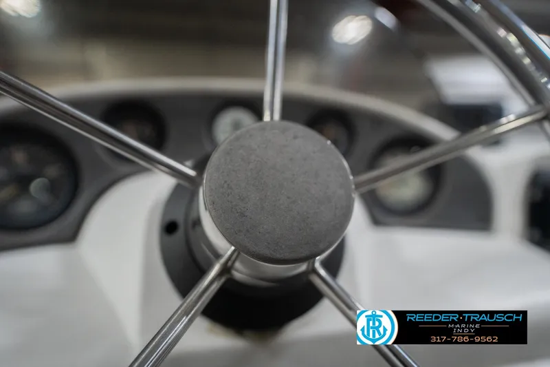 Slide: The Image of Steering wheel of a 1999 Landau DX24 boat, featuring a sleek metal design. - 32