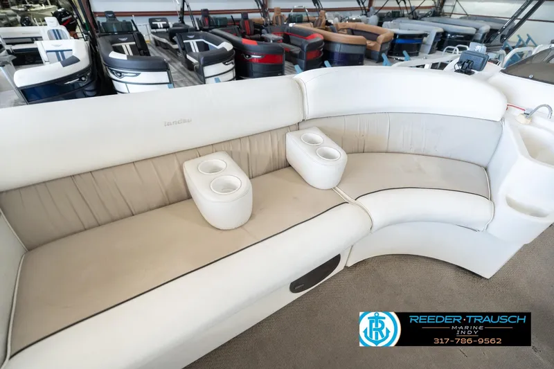 Slide: The Image of 1999 Landau DX24 boat interior with white seating and cup holders. - 42
