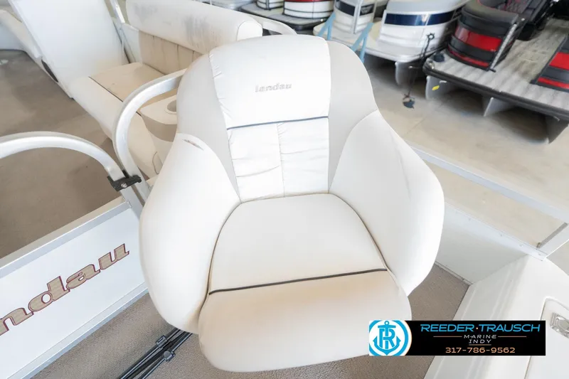 Slide: The Image of White captain's chair on a 1999 Landau DX24 boat, showroom setting. - 43