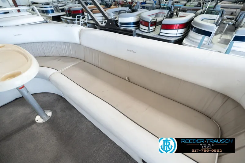 Slide: The Image of 1999 Landau DX24 boat interior with beige seating and table, displayed at Reeder Trausch Marine. - 44