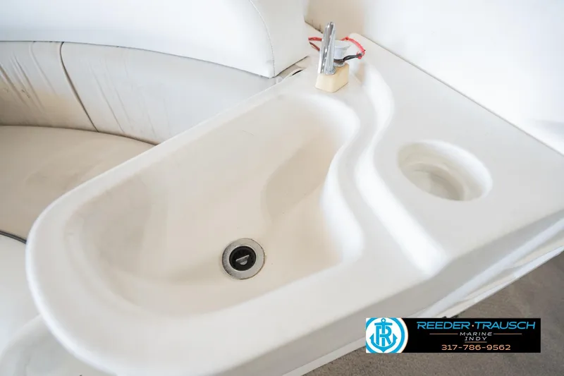 Slide: The Image of White sink on a 1999 Landau DX24 boat with faucet and cup holder. - 48