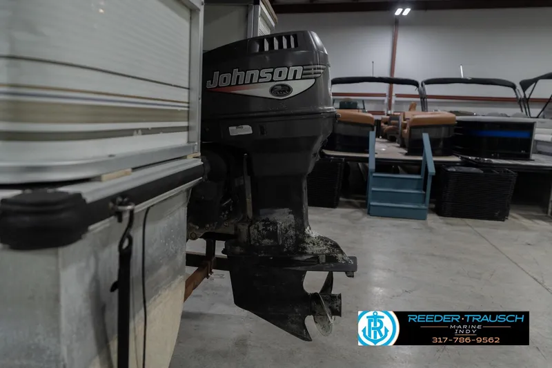 Slide: The Image of 1999 Landau DX24 with Johnson outboard motor in a showroom setting. - 50