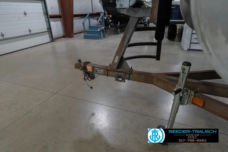 Slide: The Image of Trailer hitch of a 1999 Landau DX24 boat in a garage setting. - 56