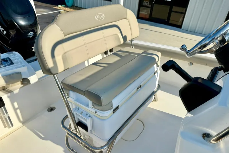 Slide: The Image of 2022 Key West 188 Bay Reef boat seat and console, featuring beige upholstery and steering controls. - 19