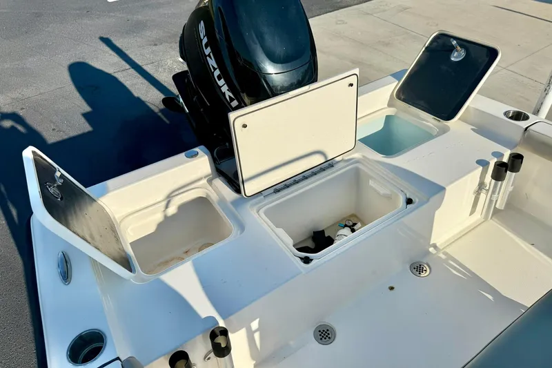 Slide: The Image of 2022 Key West 188 Bay Reef boat with open storage compartments and Suzuki outboard motor. - 26
