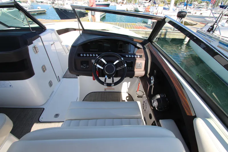 Slide: The Image of 2016 Cobalt R30 boat cockpit with steering wheel, dashboard, and marina view. - 29