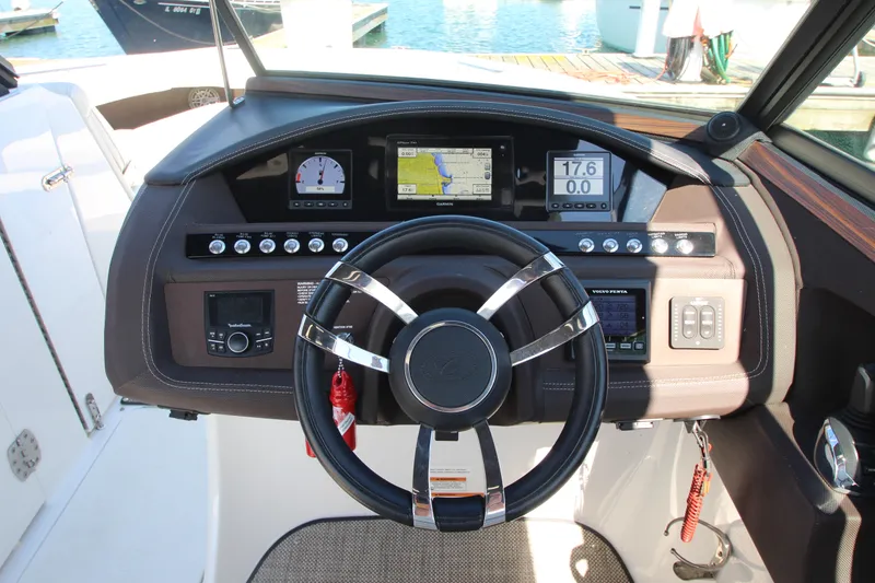 Slide: The Image of Steering wheel and dashboard of a 2016 Cobalt R30 boat, featuring navigation and control instruments. - 49