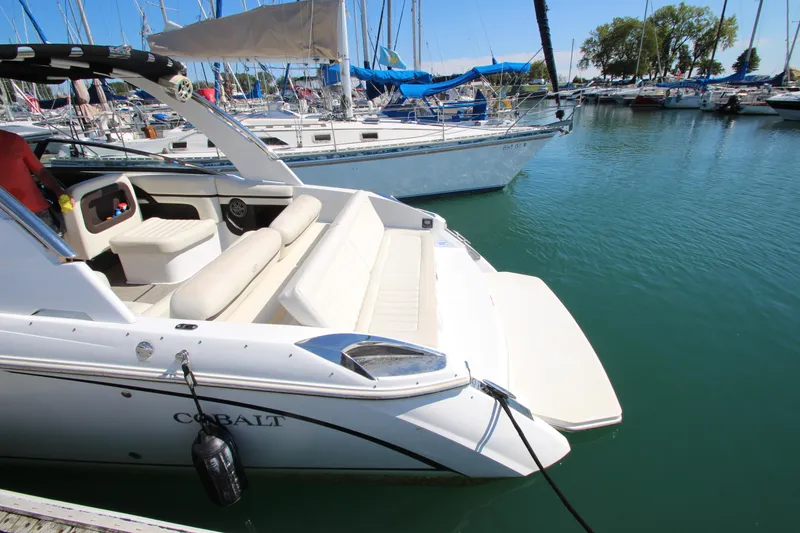 Slide: The Image of 2016 Cobalt R30 boat docked in a marina with sailboats in the background. - 7