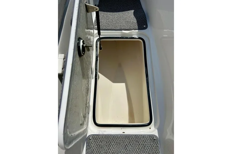 Slide: The Image of Open storage compartment on a 2008 Yamaha 212X boat, featuring carpeted flooring. - 27
