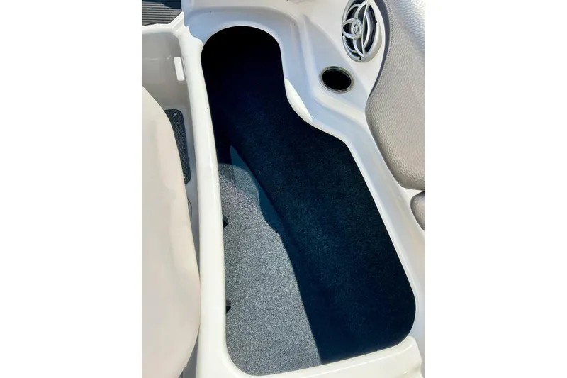 Slide: The Image of Interior storage compartment of 2008 Yamaha 212X boat, featuring carpeted flooring and speaker. - 28