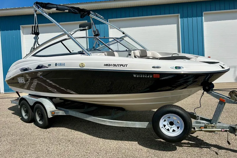 Slide: The Image of 2008 Yamaha 212X boat on trailer, high output model, parked near blue building. - 3